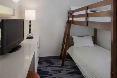 a bedroom with a bunk bed and a television at Fairfield Inn & Suites by Marriott Orlando Lake Buena Vista in Orlando