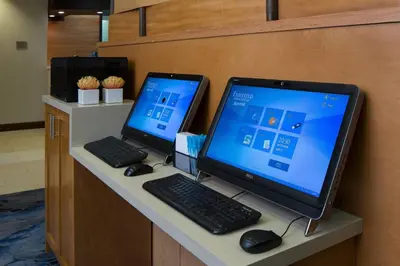 a desk with two computer monitors and a keyboard and mouse at Fairfield Inn & Suites by Marriott Orlando Lake Buena Vista in Orlando