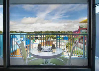 a balcony with a table and chairs and a playground at Ramada by Wyndham Flamingo Water Park in Kissimmee