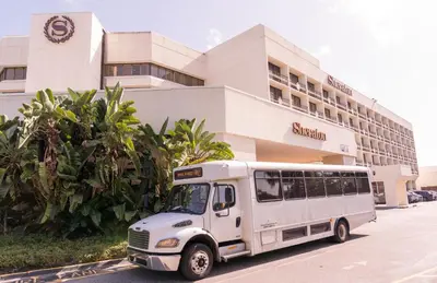 a white bus parked in front of a hotel at Sheraton Orlando Lake Buena Vista Resort in Orlando