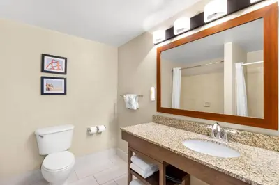 a bathroom with a sink and a toilet and a mirror at Comfort Suites Near Universal Orlando Resort in Orlando