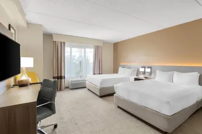 a hotel room with two beds and a desk at Comfort Suites Near Universal Orlando Resort in Orlando
