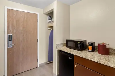 a room with a microwave on a counter with a door at Comfort Suites Near Universal Orlando Resort in Orlando