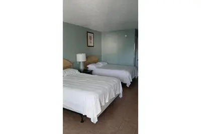 a bedroom with two beds and a mirror at Siesta Motor Inn Kissimmee Near Disney World in Kissimmee