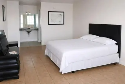 a bedroom with a large white bed and a television at Siesta Motor Inn Kissimmee Near Disney World in Kissimmee