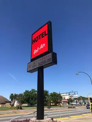 a sign for a hotel on the side of a road at Hotel Belair Orlando Near Florida Mall in Orlando