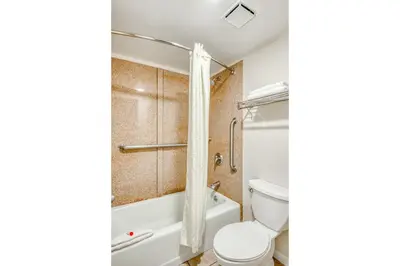 a bathroom with a toilet and a tub and a shower at Hotel Belair Orlando Near Florida Mall in Orlando