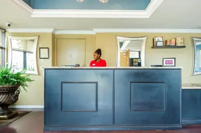 a woman standing behind a blue counter in a salon at Hotel Belair Orlando Near Florida Mall in Orlando