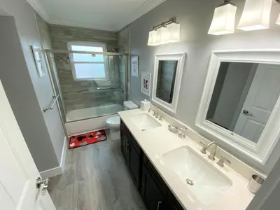 a bathroom with two sinks and a shower and a toilet at Mickeys Pearl - Phenomenal 7BR with 4 Master Suites Privacy Pool & Hot Tub Gas BBQ - 2 miles to Disney in Orlando