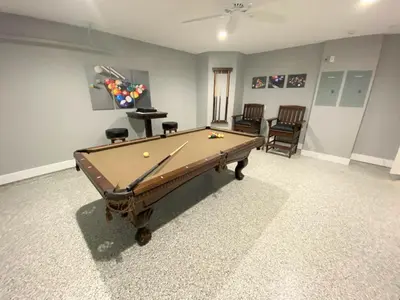 a room with a pool table and two chairs at Mickeys Pearl - Phenomenal 7BR with 4 Master Suites Privacy Pool & Hot Tub Gas BBQ - 2 miles to Disney in Orlando