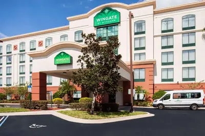 a hotel with a van parked in front of it at Wingate By Wyndham - Orlando International Airport- Free Hot Breakfast in Orlando