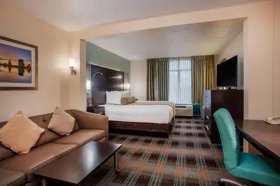 a hotel room with a bed and a couch at Wingate By Wyndham - Orlando International Airport- Free Hot Breakfast in Orlando