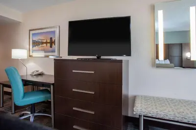 a hotel room with a desk and a flat screen tv at Wingate By Wyndham - Orlando International Airport- Free Hot Breakfast in Orlando