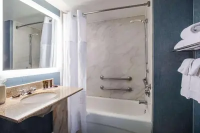 a bathroom with a tub and a sink and a shower at Wingate By Wyndham - Orlando International Airport- Free Hot Breakfast in Orlando