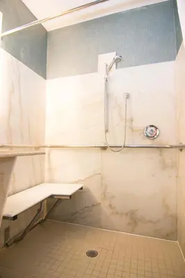 a bathroom with a shower and a bench at Wingate By Wyndham - Orlando International Airport- Free Hot Breakfast in Orlando