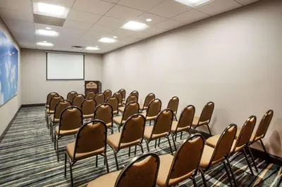 a conference room with chairs and a whiteboard at Wingate By Wyndham - Orlando International Airport- Free Hot Breakfast in Orlando