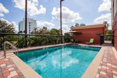 a swimming pool on the side of a building at Wingate By Wyndham - Orlando International Airport- Free Hot Breakfast in Orlando