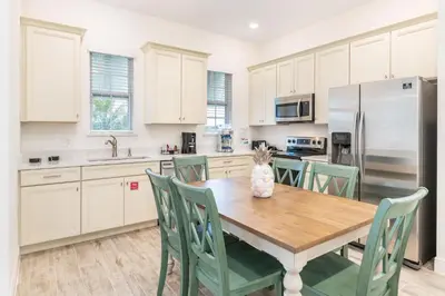 a kitchen with a wooden table with a cat sitting on it at Sunrise Cottage Near Disney With Margaritaville Resort & Island H20 Waterpark Access - 2988Sr in Orlando