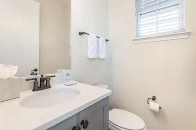 a white bathroom with a sink and a toilet at Setting Sail Cottage With Private Hot Tub Near Disney With Margaritaville Resort & Island H2O Access - 8057Dr in Orlando