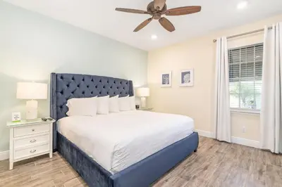 a bedroom with a bed and a ceiling fan at Setting Sail Cottage With Private Hot Tub Near Disney With Margaritaville Resort & Island H2O Access - 8057Dr in Orlando