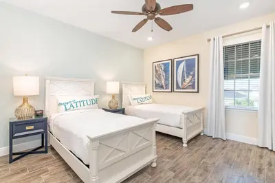 a bedroom with two beds and a ceiling fan at Setting Sail Cottage With Private Hot Tub Near Disney With Margaritaville Resort & Island H2O Access - 8057Dr in Orlando