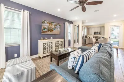 a living room with a couch and a table at Setting Sail Cottage With Private Hot Tub Near Disney With Margaritaville Resort & Island H2O Access - 8057Dr in Orlando