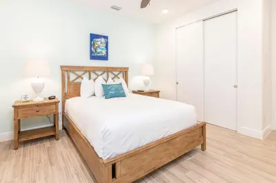 a bedroom with a bed and two nightstand tables at Sandcastles & Sunshine Cottage With Private Pool Near Disney With Margaritaville Resort & Island H20 Access - 8025Su in Orlando
