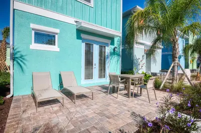 a patio with chairs and a table in front of a house at Salt Water Cottage Near Disney With Margaritaville Resort & Island H2O Access - 8012Dr in Orlando