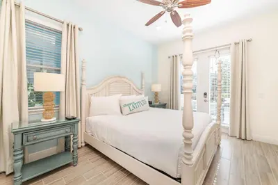 a white bedroom with a bed and a ceiling fan at Salt Water Cottage Near Disney With Margaritaville Resort & Island H2O Access - 8012Dr in Orlando