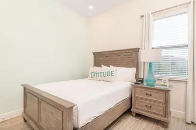 a bedroom with a wooden bed and a window at Salt Water Cottage Near Disney With Margaritaville Resort & Island H2O Access - 8012Dr in Orlando