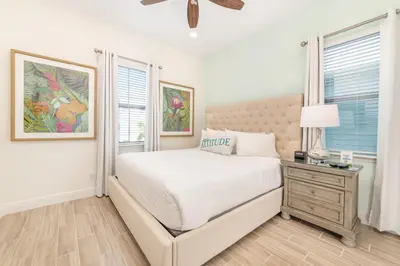 a white bedroom with a bed and a window at Salt Water Cottage Near Disney With Margaritaville Resort & Island H2O Access - 8012Dr in Orlando