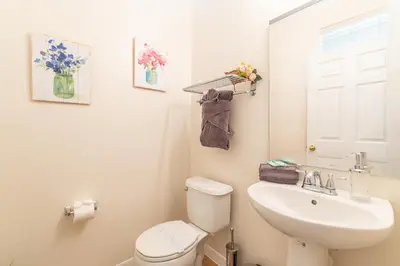 a white bathroom with a toilet and a sink at Lovely Disney Vacation House in Orlando