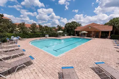 a large swimming pool with chairs around it at Lovely Disney Vacation House in Orlando