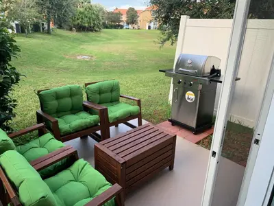 a patio with two chairs and a grill with a stove at Lovely Disney Vacation House in Orlando