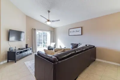 a living room with a large brown leather couch at Terra Verde Resort!! Private Pool, Game Room, Near Disney And Universal!! in Kissimmee