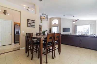 a dining room and living room with a table and chairs at Terra Verde Resort!! Private Pool, Game Room, Near Disney And Universal!! in Kissimmee