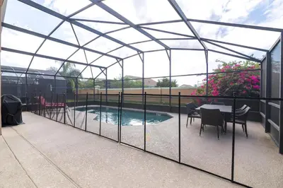 a glass greenhouse with a table and chairs next to a pool at Terra Verde Resort!! Private Pool, Game Room, Near Disney And Universal!! in Kissimmee