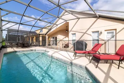 a swimming pool with a glass roof and two chairs at Terra Verde Resort!! Private Pool, Game Room, Near Disney And Universal!! in Kissimmee