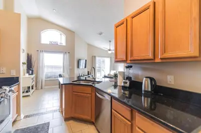 a kitchen with wooden cabinets and a counter top at Terra Verde Resort!! Private Pool, Game Room, Near Disney And Universal!! in Kissimmee