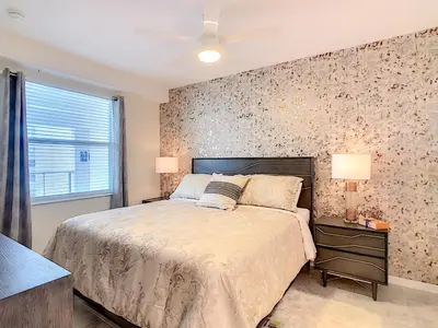 a bedroom with a bed and a wall with flowers at Splendid Thematic 2BR with Waterpark in Kissimmee