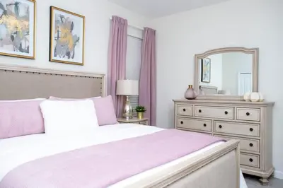 a bedroom with a bed and a dresser and a mirror at Gorgeous 5 Bd Single Family Close to Disney @ Storey Lake Resort 2734 in Kissimmee