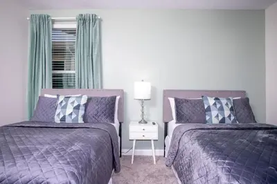 two beds sitting next to each other in a bedroom at Gorgeous 5 Bd Single Family Close to Disney @ Storey Lake Resort 2734 in Kissimmee