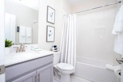 a white bathroom with a sink and a toilet at Gorgeous 5 Bd Single Family Close to Disney @ Storey Lake Resort 2734 in Kissimmee