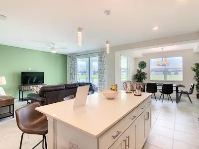 a kitchen and living room with a large island at Lakeview Themed 2BR Condo with Waterpark Access in Kissimmee