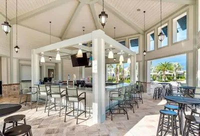 a covered patio with tables and chairs and a bar at Lakeview Themed 2BR Condo with Waterpark Access in Kissimmee