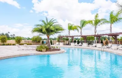 a swimming pool at a resort with chairs and palm trees at Great townhouse in great luxurious community, poolgym Close to Disney! in Kissimmee