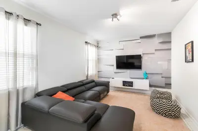 a living room with a couch and a flat screen tv at 2957 FS - Luxury Oasis: 6BR Villa Pool Game in Kissimmee