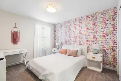 a bedroom with a white bed and a colorful wall at 2957 FS - Luxury Oasis: 6BR Villa Pool Game in Kissimmee