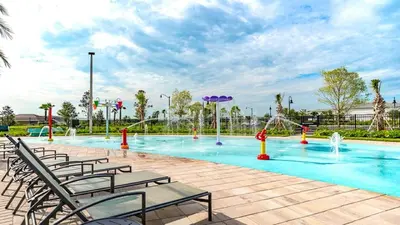 a large pool with chairs and a water park at 4801 ML - Ideal Retreat Townhome Oasis with Pool in Kissimmee