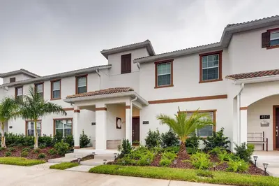 a large white building with trees and plants at 4808 LL Magical 4BR Disney Townhome Pool in Kissimmee